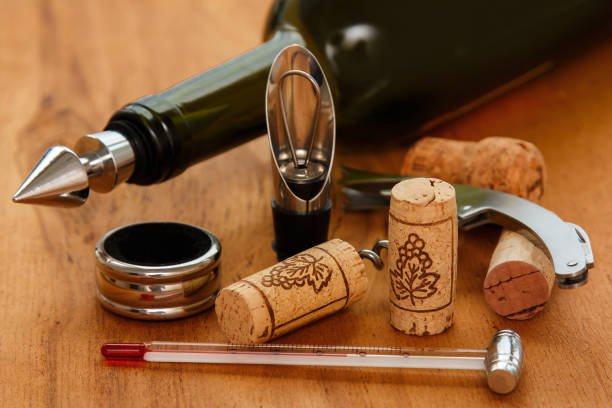 Different wine tools and corks on wooden surface